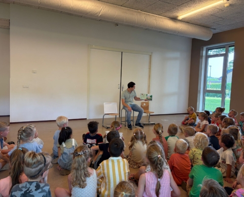 Stefan van Ballegooie leest Ezra heeft een hart van goud voor aan 86 kinderen van de Julianaschool in Dordrecht